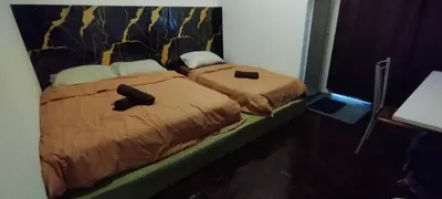 two beds sitting next to each other in a room at Segambut Homestay MITEC KLCC PWTC 13 paxs in Kuala Lumpur