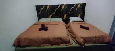 two beds sitting next to each other in a room at Segambut Homestay MITEC KLCC PWTC 13 paxs in Kuala Lumpur