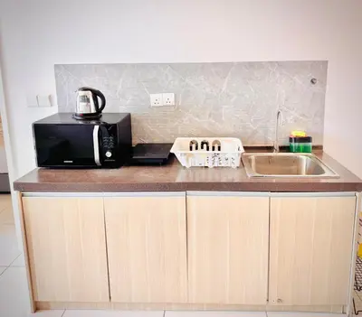 a kitchen counter with a microwave and a sink at Robertson Residence by Aspire Suites in Kuala Lumpur