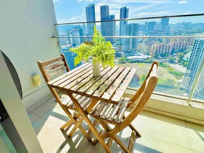 a wooden table and two chairs on a balcony with a view at Robertson Residence by Aspire Suites in Kuala Lumpur
