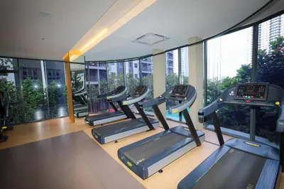 a gym with several treadmills in a building with windows at M Arisa KL City View by AT in Kuala Lumpur