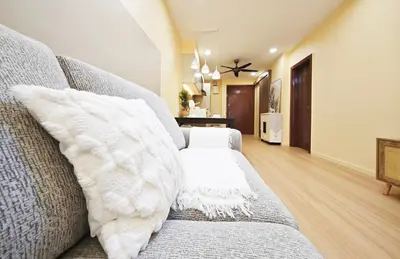 a living room with a gray couch with white pillows at Bukit Bintang Fairlane Residence #1810 Kuala Lumpur in Kuala Lumpur