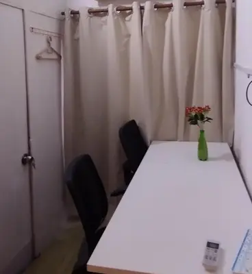 a table with two chairs and a vase with flowers on it at Segambut House near MITEC KLCC PWTC 14 paxs in Kuala Lumpur