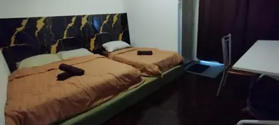 two beds sitting next to each other in a room at Segambut House near MITEC KLCC PWTC 14 paxs in Kuala Lumpur