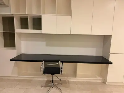 a black desk with a chair and white cabinets at Platinum kuala lumpur by Bright Suites in Kuala Lumpur