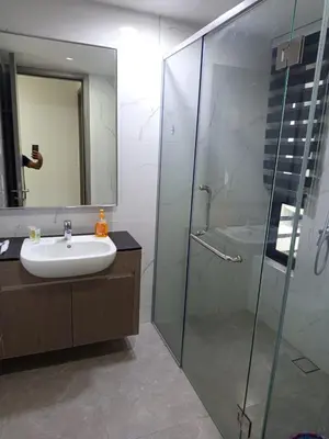a bathroom with a sink and a glass shower at KL Residence By Agile Suites in Kuala Lumpur