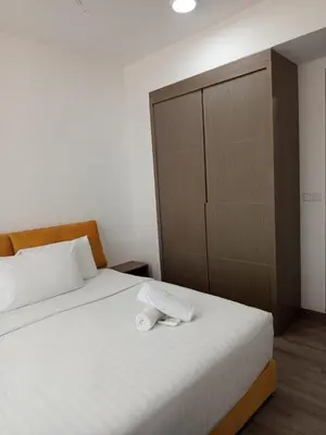 a bedroom with two beds and a large cabinet at KL Residence By Agile Suites in Kuala Lumpur