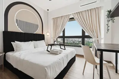 a bedroom with a bed and a desk and a window at Deluxe 2BR Agile Bukit Bintang by RumaBnB in Kuala Lumpur