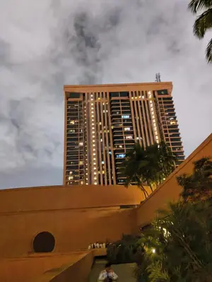 a tall building is lit up at night at Home World Apartment At Times Square in Kuala Lumpur
