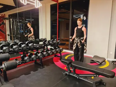 a woman standing in front of a row of gym equipment at Home For Traveler At Majestic Residence in Kuala Lumpur