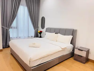 a bedroom with a large bed with white sheets at Lucentia Universal Stay Kuala Lumpur in Kuala Lumpur
