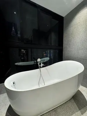 a white bath tub in a bathroom with a window at KLCC View Suites By Scarletz in Kuala Lumpur