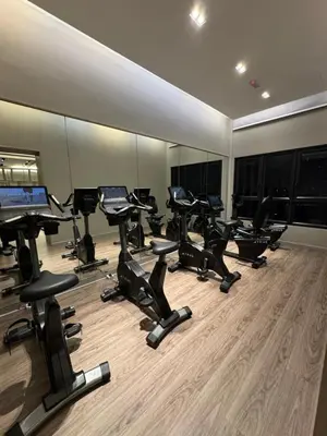 a gym with a row of exercise bikes and mirrors at KLCC View Suites By Agile in Kuala Lumpur