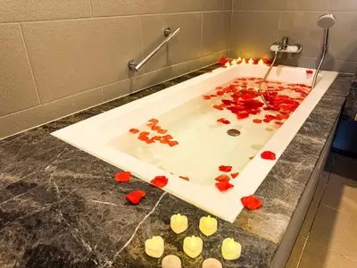 a bath tub filled with red roses on a bathroom counter at KLCC Spacious Top Floor, Grand, Slides and Big Bathtub Kula Lumpur in Kuala Lumpur