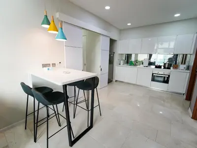 a kitchen with a white table and stools at Tomato Homestay By Sky Suites KLCC in Kuala Lumpur