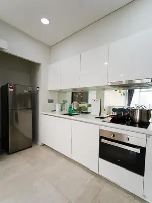 a kitchen with white cabinets and stainless steel appliances at Tomato Homestay By Sky Suites KLCC in Kuala Lumpur