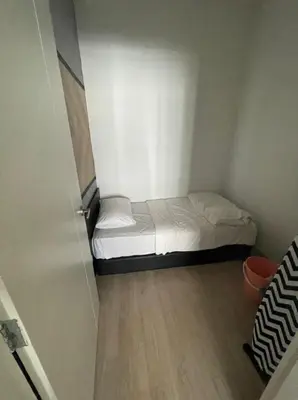 a small bed in a small room with a wooden floor at Arte Plus Homestay Condo in Kuala Lumpur