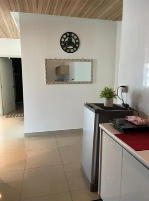 a kitchen with a white wall with a clock on the wall at Arte Plus Homestay Condo in Kuala Lumpur
