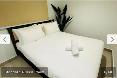 a bedroom with a white bed with a cross on it at Hotel Bintang Inn in Kuala Lumpur