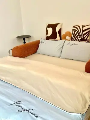 a bed with a couch and pillows in a room at Only Girls Condo at KL city, near monorail in Kuala Lumpur