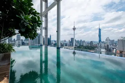 a swimming pool on the roof of a building with a city at The Colony By Feel Home in Kuala Lumpur