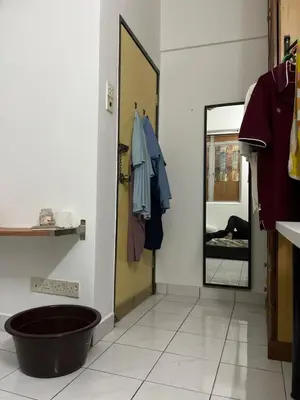 a room with a mirror and a door with a person laying on a bed at Regalia Residence in Kuala Lumpur