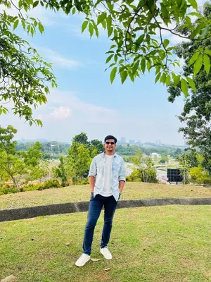 a man is standing in a grass field at Regalia Residence in Kuala Lumpur