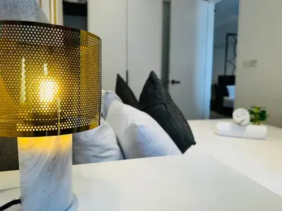 a lamp on a table next to a couch at Crystal At Axon Residence KL in Kuala Lumpur