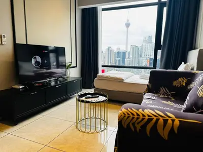 a living room with a couch and a large window at Crystal At Axon Residence KL in Kuala Lumpur