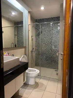 a bathroom with a toilet and a glass shower at Bukit Bintang By Eryan Guest House in Kuala Lumpur
