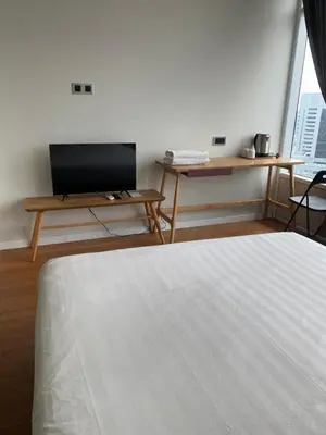 a bedroom with a bed and a table and a tv at SKY suits private room apartments in Kuala Lumpur