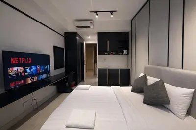 a bedroom with a white bed and a flat screen tv at Axon Bukit Bintang By Sleeping Bird in Kuala Lumpur