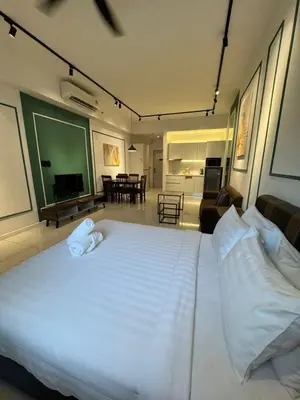 a bedroom with a large white bed and a living room at Chamber Residence klcc by Cozy white in Kuala Lumpur
