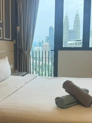 a bedroom with a bed with a view of a city at The Luxe KLCC By Serviced Apartment in Kuala Lumpur