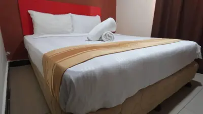 a bedroom with a large bed with a red headboard at Hotel Wings Kuala Lumpur in Kuala Lumpur