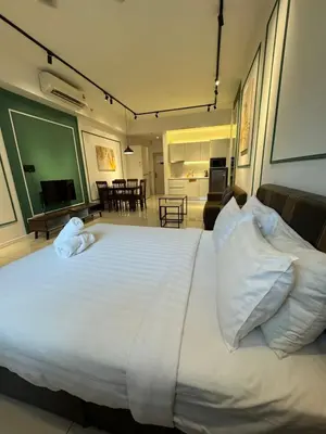 a large white bed in a room with a living room at Chamber Residence klcc by Cozy Dream in Kuala Lumpur
