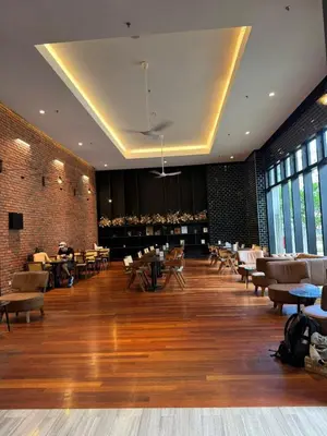 a restaurant with tables and chairs in a room with wooden floors at Chamber Residence klcc by Cozy Dream in Kuala Lumpur