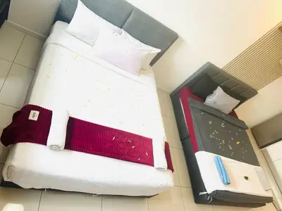 a bed with white sheets and red and white pillows at Cherry Homes at Chambers by Golden in Kuala Lumpur
