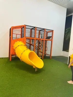 a playground with a yellow slide on the grass at Cherry Homes at Chambers by Golden in Kuala Lumpur