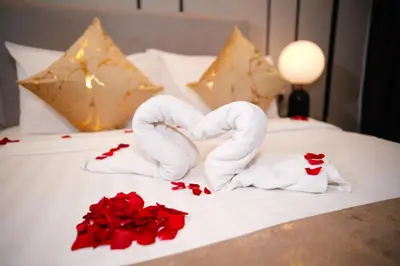 two towels in the shape of a heart on a bed at Axon Residence KLCC - CK Homestay in Kuala Lumpur