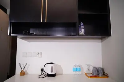 a kitchen with black cabinets and a microwave at Axon Residence KLCC - CK Homestay in Kuala Lumpur