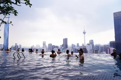 a group of people in a infinity pool on the roof of a building at Axon Residence KLCC - CK Homestay in Kuala Lumpur