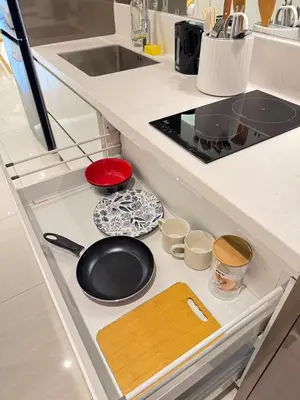 a kitchen drawer with a frying pan and bowls at Dorsett Hartamas with Rooftop Pool and Bathtub in KL City #215 in Kuala Lumpur