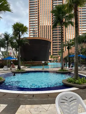 a large swimming pool with palm trees and buildings at Apartment TS at Times Square in Kuala Lumpur