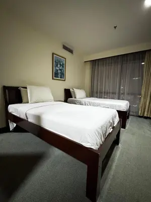 two twin beds in a room with a window at Texas Service Suites At BTS Kuala Lumpur in Kuala Lumpur