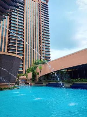 a large pool of blue water in front of tall buildings at Texas Service Suites At BTS Kuala Lumpur in Kuala Lumpur