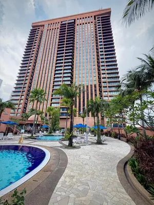 a large building with a pool in front of a resort at Texas Service Suites At BTS Kuala Lumpur in Kuala Lumpur