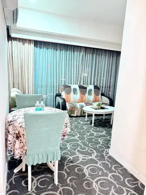 a room with a couch and a table and chairs at Texas Service Suites At BTS Kuala Lumpur in Kuala Lumpur