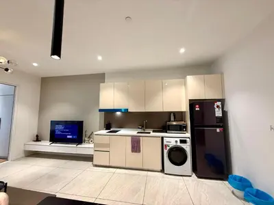 a kitchen with a refrigerator and a washer and dryer at Kualalumpur Quill Residences Suites By KLCC in Kuala Lumpur