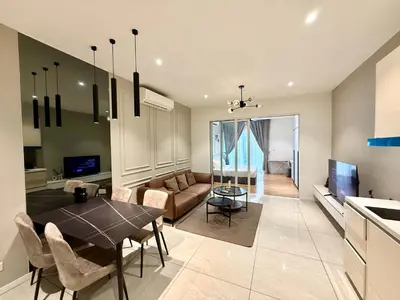 a kitchen and living room with a table and a couch at Kualalumpur Quill Residences Suites By KLCC in Kuala Lumpur